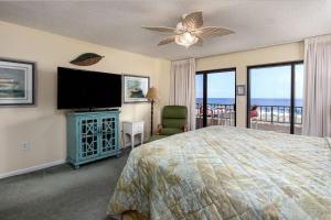 a bedroom with a bed and a flat screen tv at Surf Dweller 207 in Fort Walton Beach