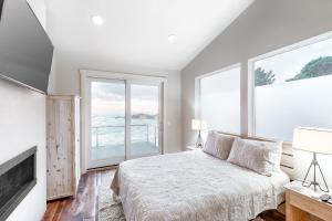 um quarto com uma cama e janelas grandes em Sea Spray Overlook em Depoe Bay