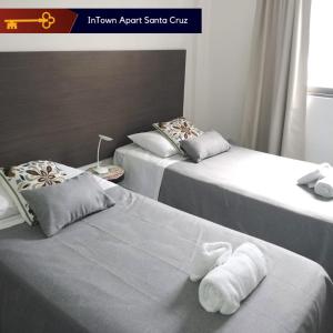 2 łóżka w pokoju hotelowym z ręcznikami w obiekcie InTown Apart Santa Cruz w mieście Santa Cruz