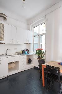 a kitchen with white cabinets and a wooden table at Your home heart of Istanbul in Istanbul
