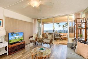 a living room with a couch and a tv at Island Sands Resort 302 in Wailuku