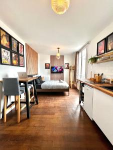 cocina y sala de estar con mesa y cama en Le Cocon proche Paris JO 2024 Centre-ville en Saint-Gratien
