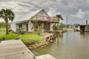 a building with a flag on it next to a river at Golden Meadow Getaway Waterfront Retreat with Deck in Golden Meadow
