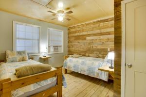 1 dormitorio con 2 camas y pared de madera en Golden Meadow Getaway Waterfront Retreat with Deck, 