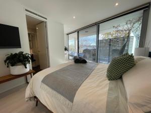 um quarto com uma cama grande e uma janela grande em Lakeview Luxe - EV charger, Pool, Gym, Location + em Kingston 
