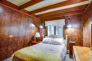 1 dormitorio con 1 cama y pared de madera en Crystal Mountain Cabin with Cozy Fireplace!, en Thompsonville