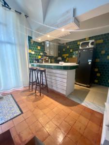 a kitchen with a counter with stools and a refrigerator at Dar chelbia in Hammamet
