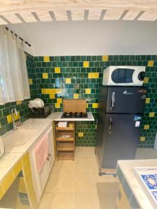 a kitchen with green and yellow tiles and a refrigerator at Dar chelbia in Hammamet