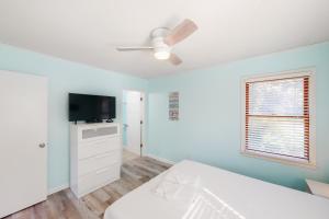 a bedroom with a bed and a flat screen tv at Offshore Oasis KDH101 in Kill Devil Hills