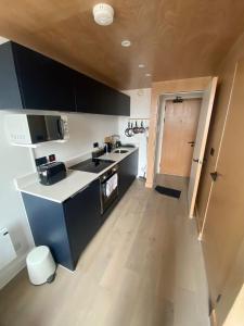 a kitchen with black and white appliances and a wooden floor at Lovely 1 Bedroom Duplex Apartment in Manchester in Manchester