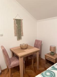 a dining room with a table and two chairs at Guest Radic Apartment 3 in Palić +8 photos