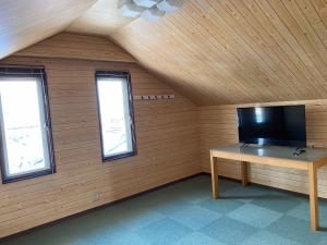 Habitación con TV en una mesa y 2 ventanas en シェアハウスの和室or洋室 24時間スーパー徒歩5分 共同ワークスペース有 en Gifu