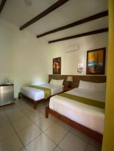 Habitación de hotel con 2 camas y TV en Konchamar en La Libertad