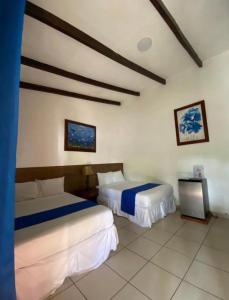 een hotelkamer met 2 bedden en een televisie bij Konchamar in La Libertad