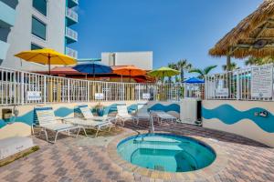 einen Pool in einem Resort mit Stühlen und Sonnenschirmen in der Unterkunft Daytona Beach Studio with Ocean View and Amenities! in Daytona Beach