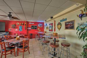 ein Restaurant mit roten Wänden, Tischen und Barhockern in der Unterkunft Daytona Beach Studio with Ocean View and Amenities! in Daytona Beach