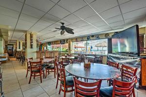 ein Restaurant mit Tischen und Stühlen und einem großen Bildschirm in der Unterkunft Daytona Beach Studio with Ocean View and Amenities! in Daytona Beach