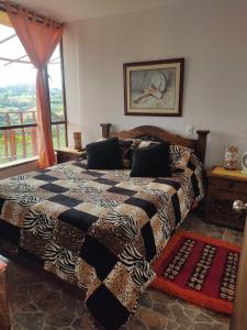 ein Schlafzimmer mit einem großen Bett und einem Fenster in der Unterkunft Balcones del Lago de Tota in Sogamoso
