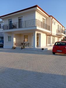 a white building with a balcony and a red car at Casa Crina in Baile Unu Mai
