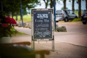 un cartel de pizarra sentado a un lado de una acera en Hotel Jans, en Rijs