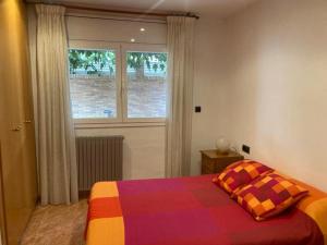 GRANDIOSO CHALET EN CASTELL DE POBLA MONTORNES في Pobla de Montornés: غرفة نوم مع سرير ملون ونافذة