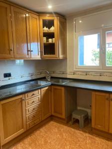 a kitchen with wooden cabinets and a sink and a window at GRANDIOSO CHALET EN CASTELL DE POBLA MONTORNES in Pobla de Montornés