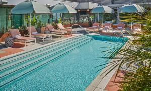 洛杉磯的住宿－Pendry West Hollywood，一个带躺椅和遮阳伞的游泳池