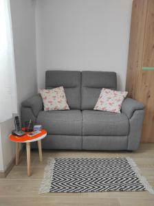 a living room with a gray couch and a table at Apartment Deeranaei in Kraljevica