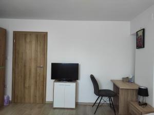 クラリェヴィツァにあるApartment Deeranaeiのテレビ、椅子、ドアが備わる客室です。