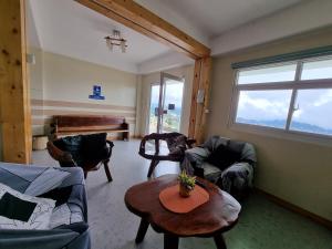 a living room with couches and a table and a piano at Wanay's Rocky Mountain Homestay in Baguio