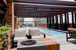 une terrasse avec un foyer extérieur et une piscine dans l'établissement Las Orquideas Zona 10, à Guatemala