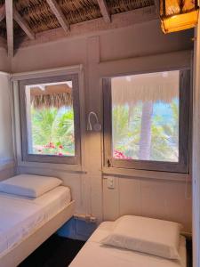 2 camas en una habitación con 2 ventanas en Nordestina Casa de Mar, en Icaraí