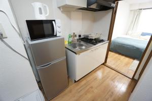 uma pequena cozinha com um lavatório e um frigorífico em Apartment Febbraio Motomachi 503 em Osaka