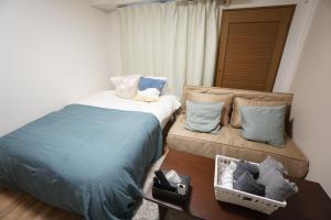 um quarto com 2 camas e uma mesa com uma mesa em Apartment Febbraio Motomachi 503 em Osaka