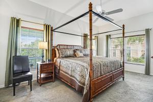 a bedroom with a canopy bed and a chair at Bayshore Panorama in Bradenton