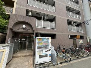 uma máquina de venda automática em frente a um edifício em Apartment Febbraio Motomachi 503 em Osaka