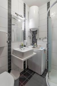 a white bathroom with a sink and a shower at Duma Apartmani Vrnjačka Banja in Vrnjci