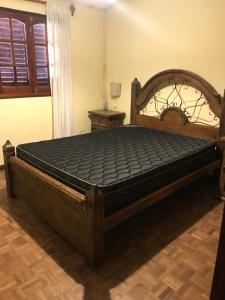 a bed in a room with a wooden bed frame at Luis marcelo in Alta Gracia +3 photos