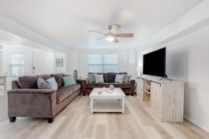 sala de estar con sofá y TV de pantalla plana en Lazy Seagull Beach House, en South Padre Island