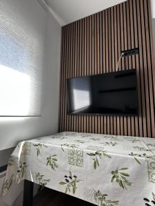 a bedroom with a bed with a television on a wall at OASIS Aqualuna & Terme Olimia G110 in Podčetrtek