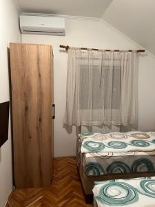 a small room with two beds and a window at Guest Radic Room in Palić