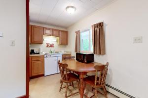 eine Küche mit einem Holztisch sowie einem kleinen Tisch und Stühlen in der Unterkunft Riverbank Connecting Motel Rooms 9 & 12 in Lincoln