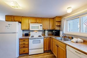 a kitchen with a white stove top oven next to a sink at Vermont Farm House and Studio in Proctorsville