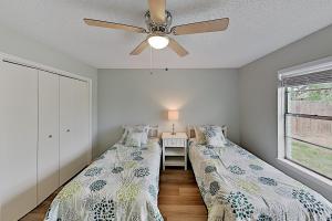 two beds in a room with a ceiling fan at Rockport Beach Club East & West in Rockport