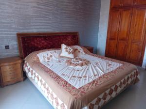 Schlafzimmer mit einem Bett und einem Holzschrank in der Unterkunft Chez Mostafa in Douar Ourlali