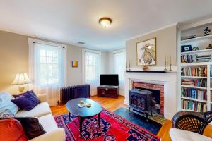 a living room with a couch and a fireplace at Full of Light Cottage in Rockland