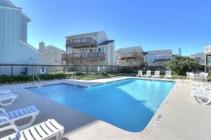a swimming pool with chairs and a house at Lost Colony #5 in Port Aransas