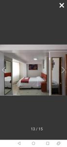 1 dormitorio con 1 cama y 2 espejos en Casa valicha ejecutivo en Cuzco