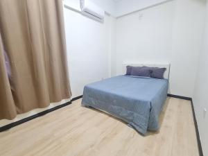 a bedroom with a bed with a blue blanket at Locahouz Homestay Sandakan in Sandakan +5 photos