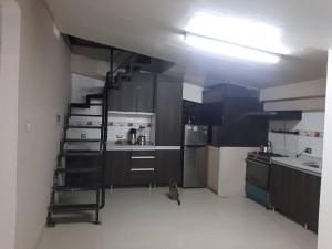 eine Küche mit einer Leiter in der Mitte eines Raumes in der Unterkunft Casa valicha ejecutivo in Cusco